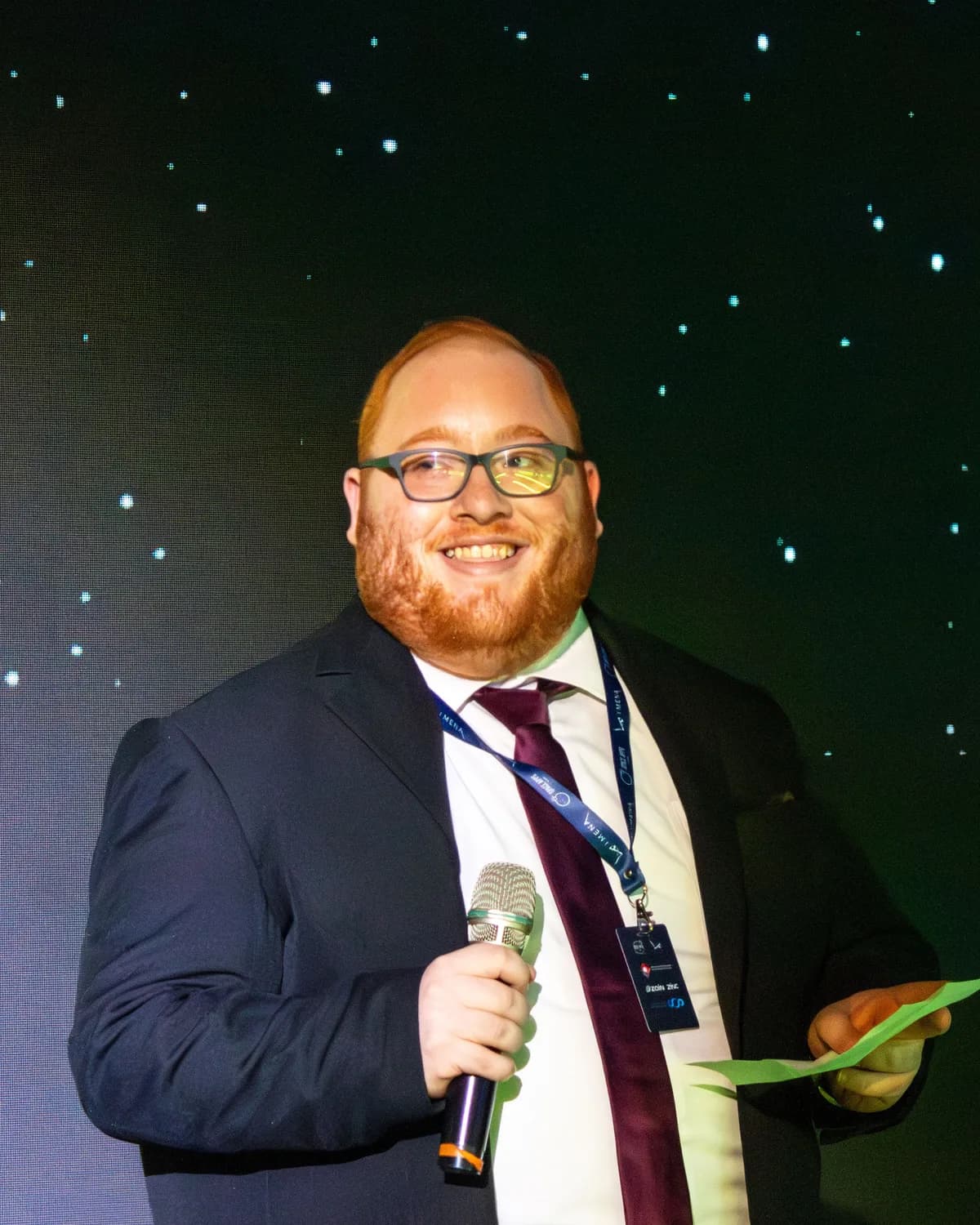Eng. Wessam Sweiss speaking at an event against a star-filled backdrop