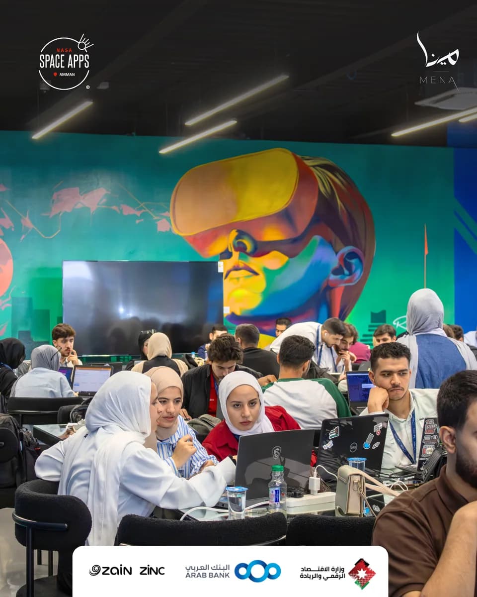 Participants collaborating at laptops during the 2025 Amman event