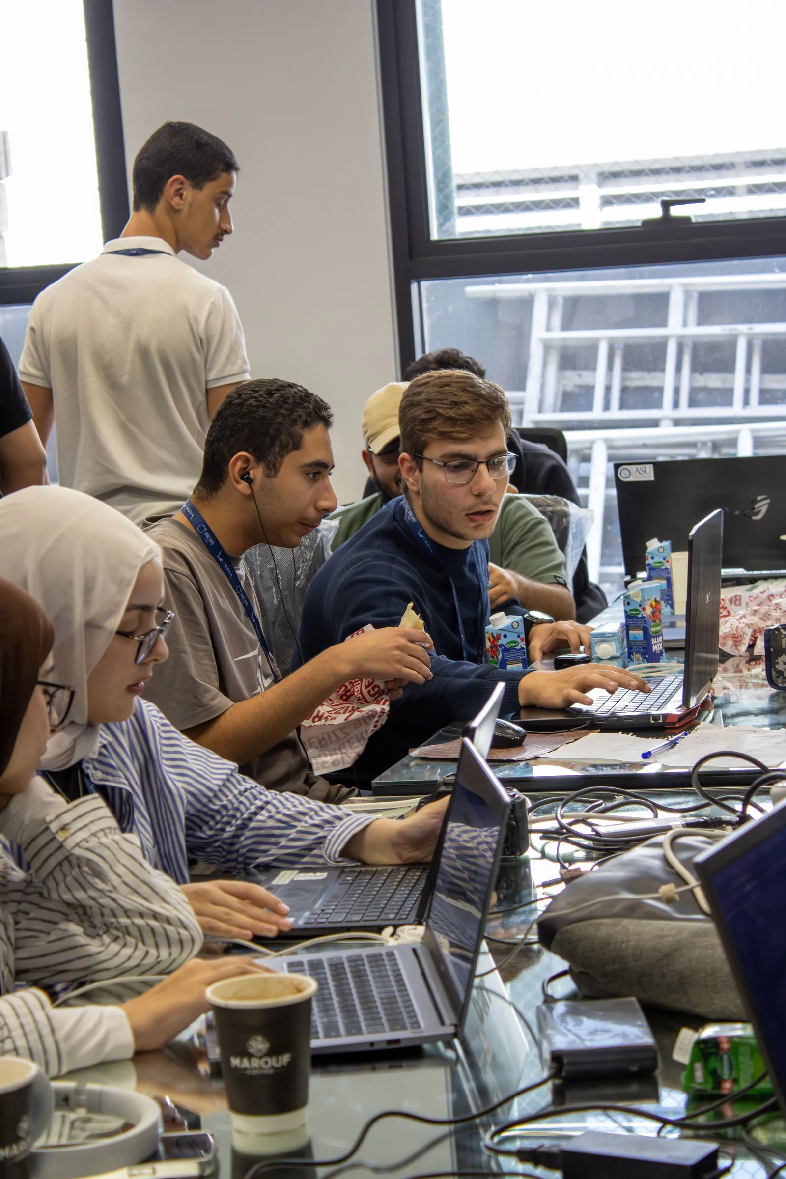 Participants gathered around a laptop, working through a problem together
